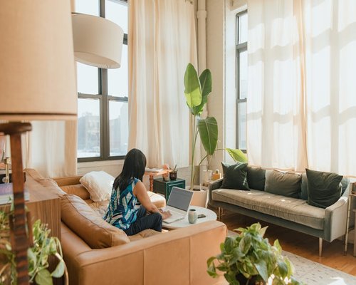A person working in a modern room with balanced ambient light filtering from a window
